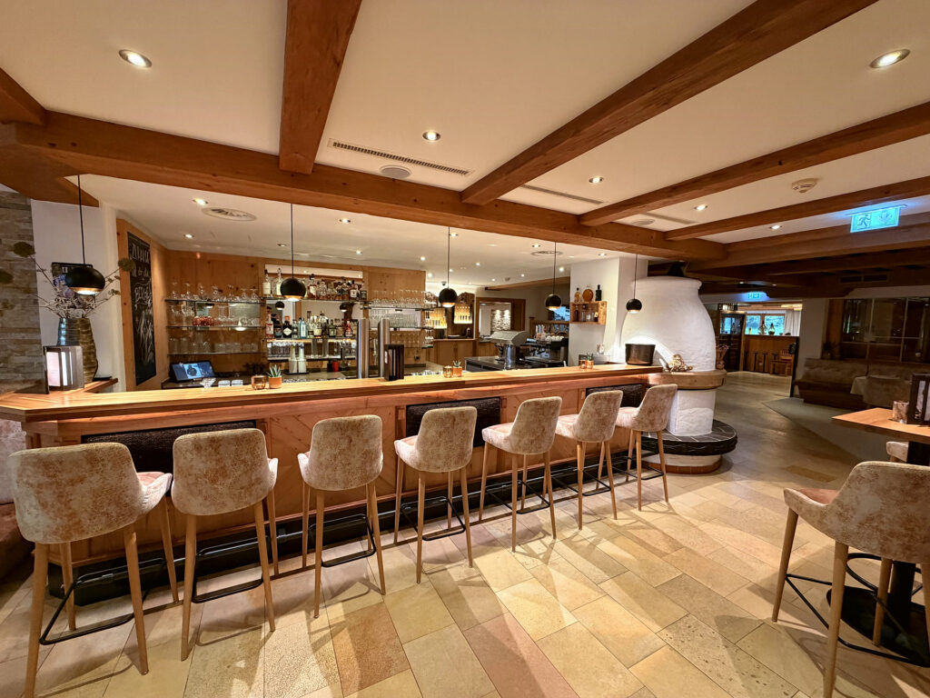 Die Hotelbar mit Holzbalken und Barhockern