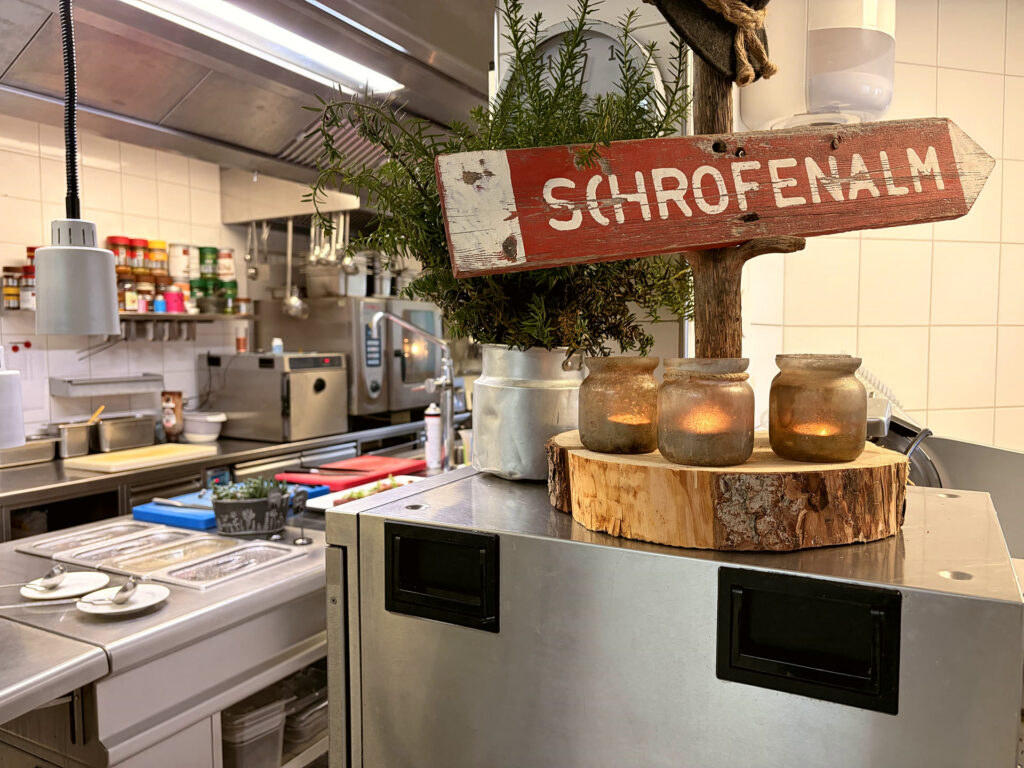 Blick in die Küche mit dem Schild der Schrofenalm